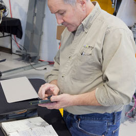 man performing routine maintenance on laser cutting system